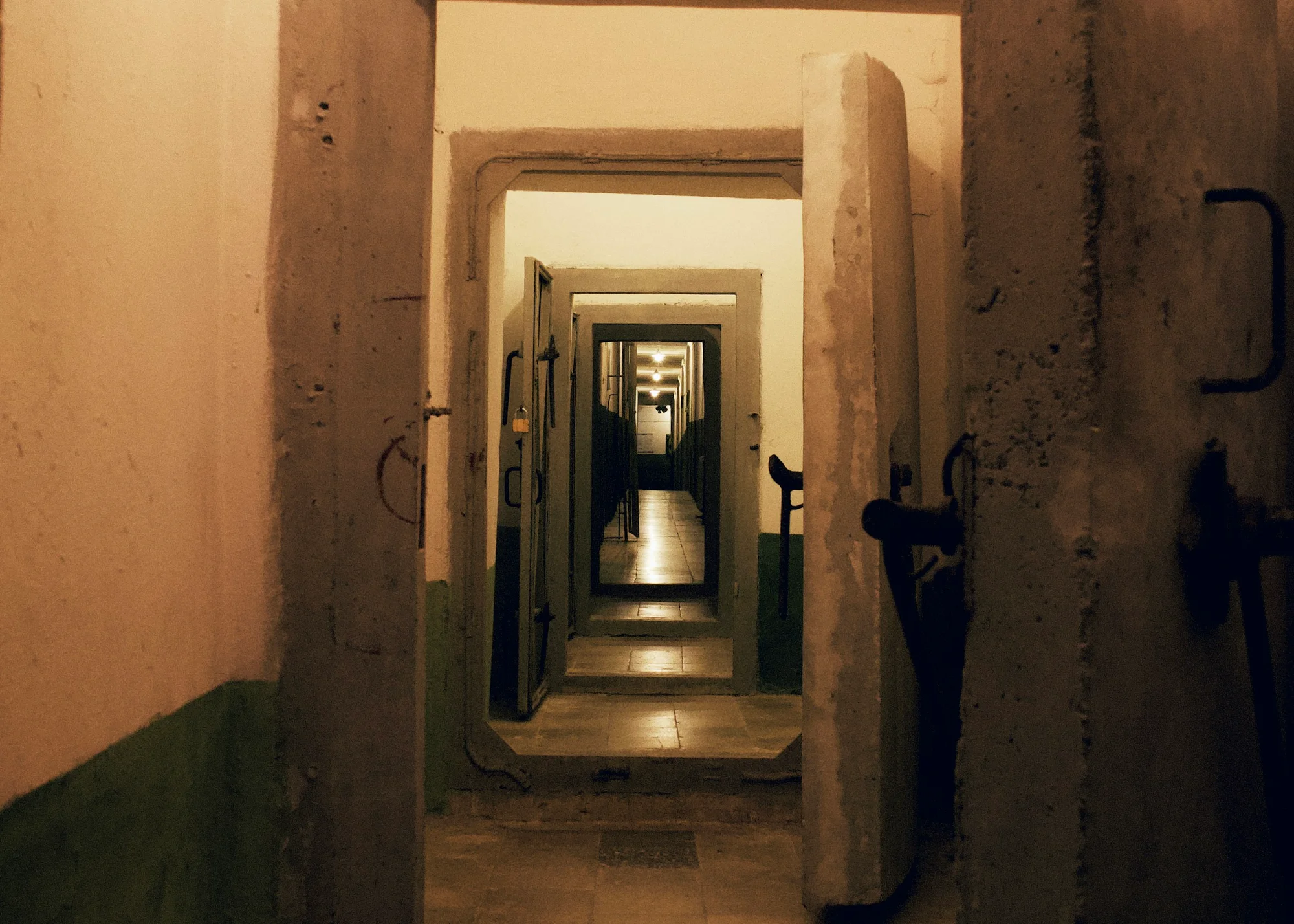 Entrance to Bunk'Art in Tirana with concrete doors and evocative warm lighting.