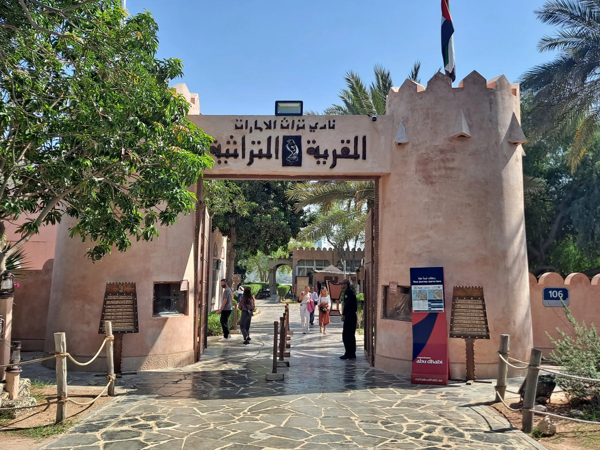 Main entrance to Heritage Village in Abu Dhabi, surrounded by traditional features and greenery.