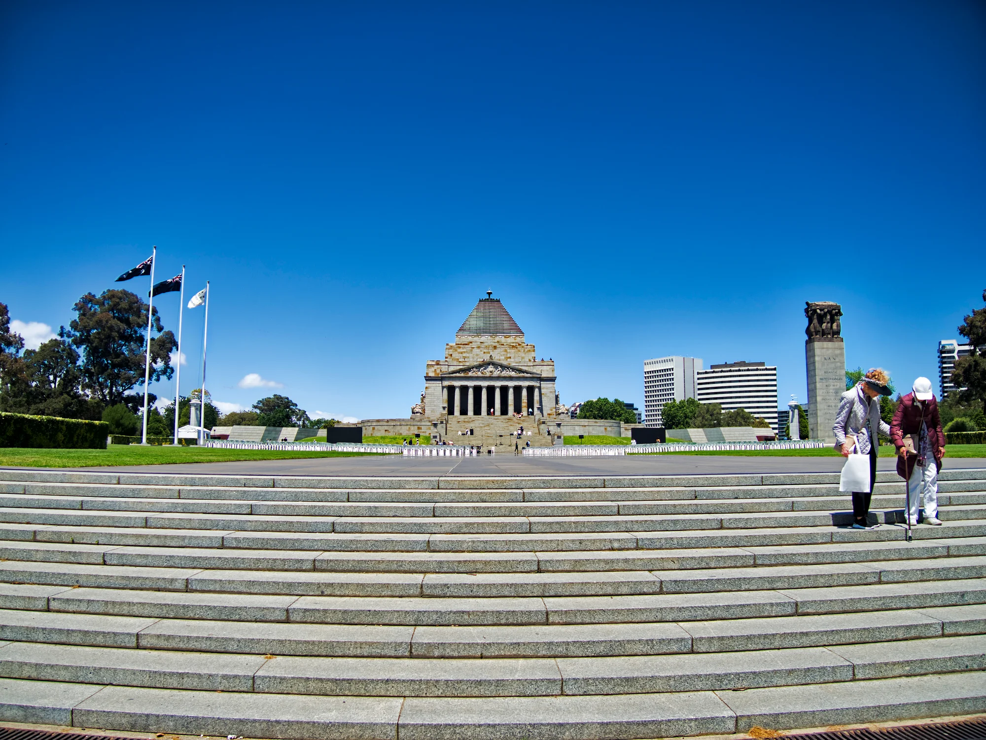 The Shrine of Remembrance Melbourne front view on a clear day with wide steps and flags flying.