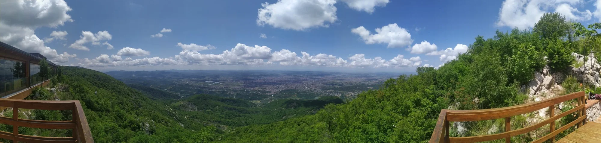 Panoramic view from Dajti Mountain, Tirana, displaying lush forests and city below.