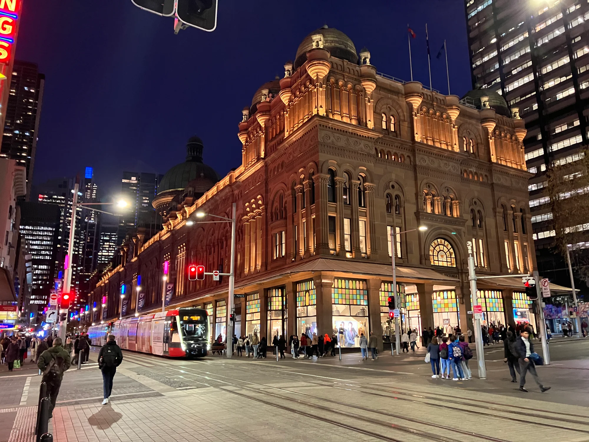 Queen Victoria Building in Sydney illuminated at night, vibrant urban setting.