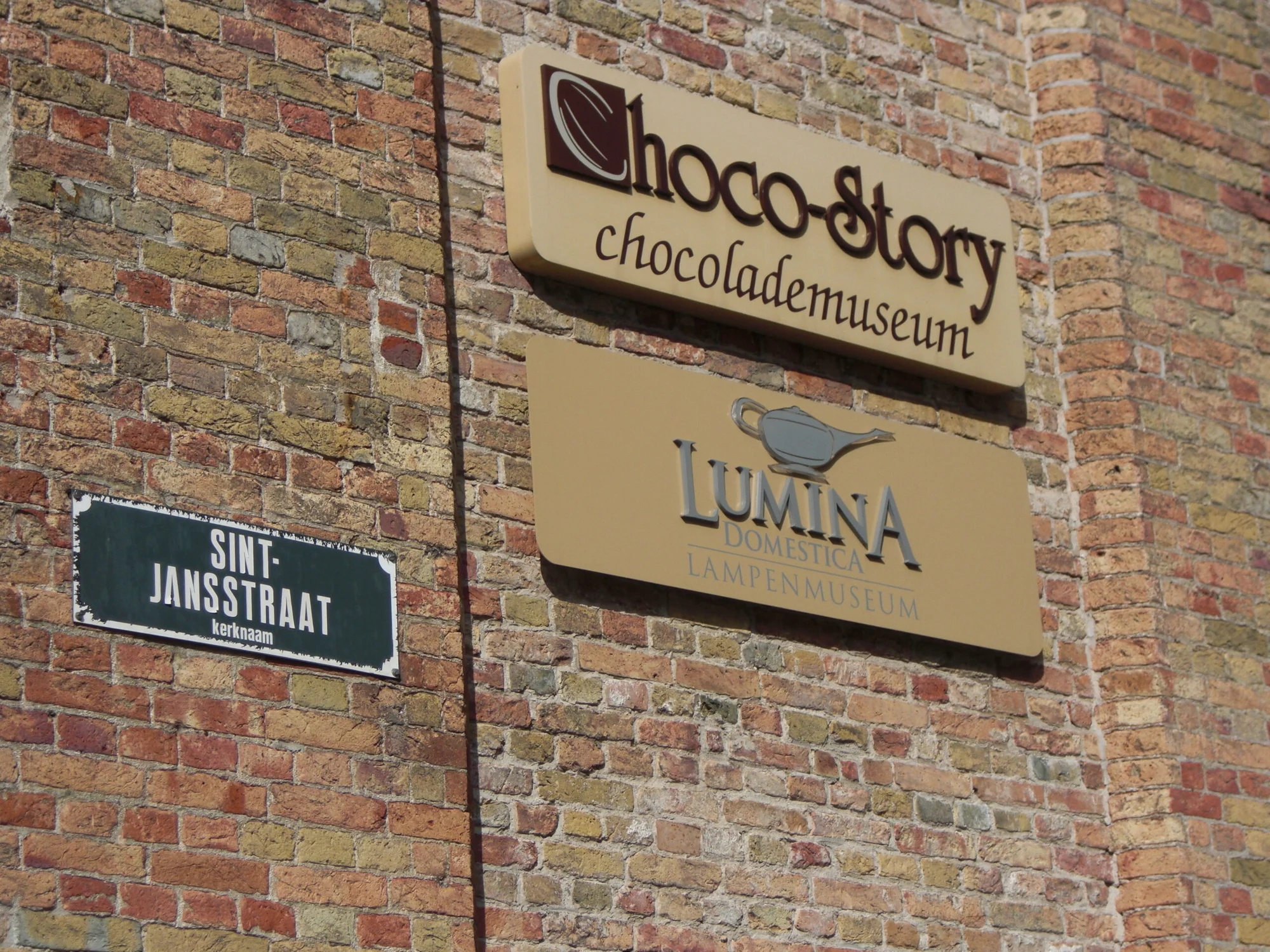 The Choco-Story Museum sign on a brick wall in Bruges, a symbol of the museum dedicated to chocolate.