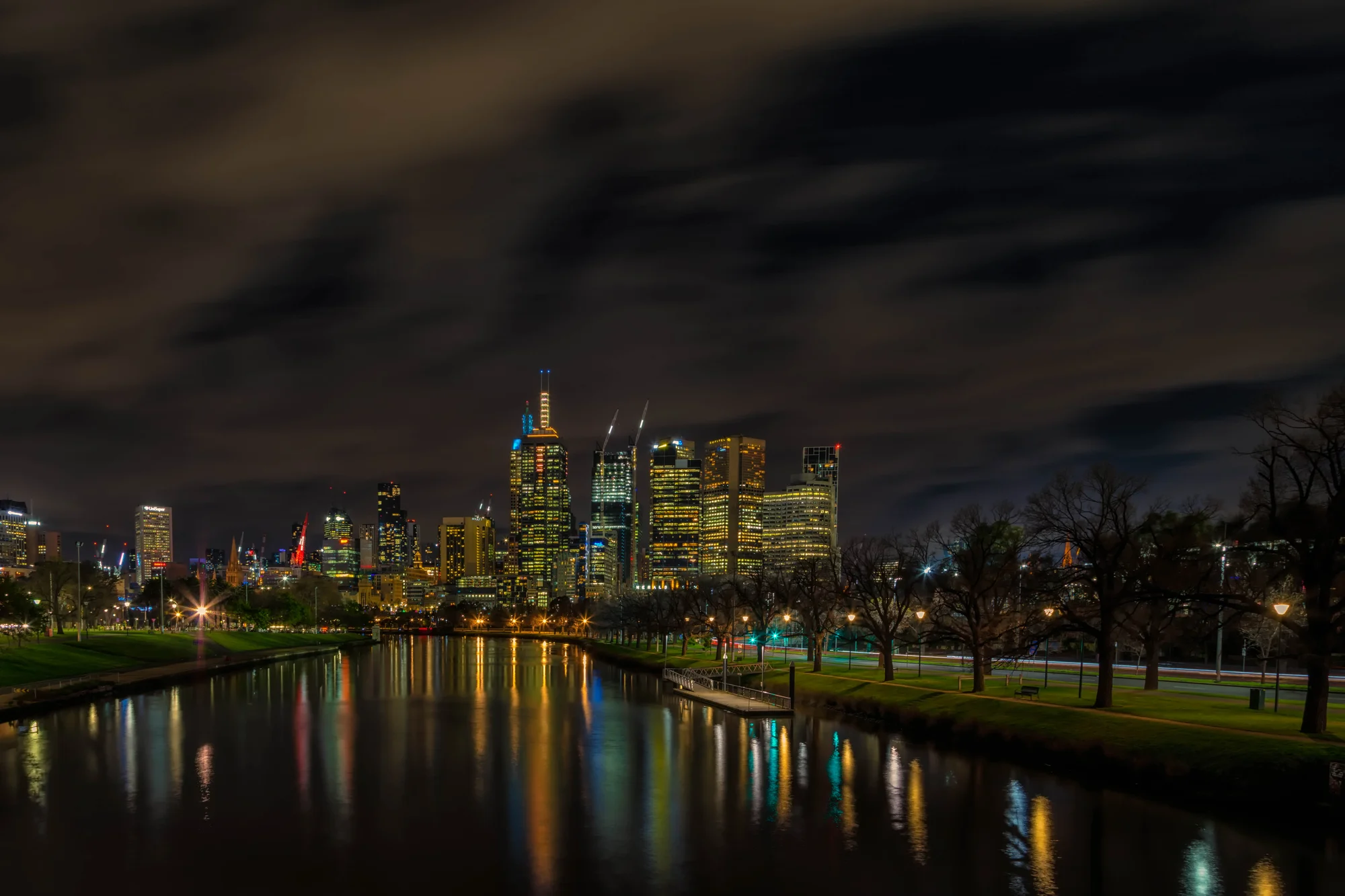 Night view of Yarra River with Melbourne's city lights reflecting in the water.