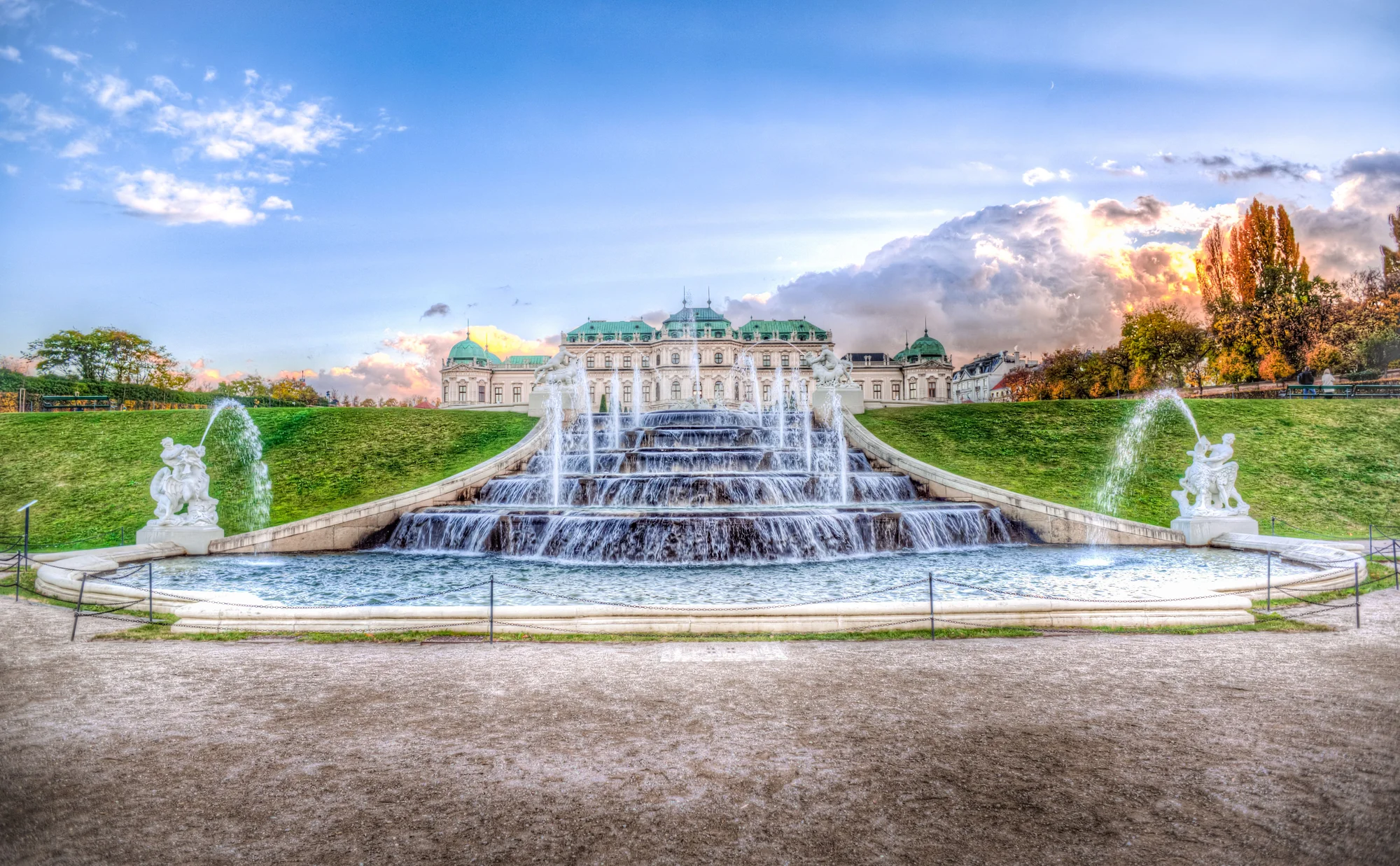 Belvedere Palace Vienna illuminated at sunset with stunning fountains in the foreground.