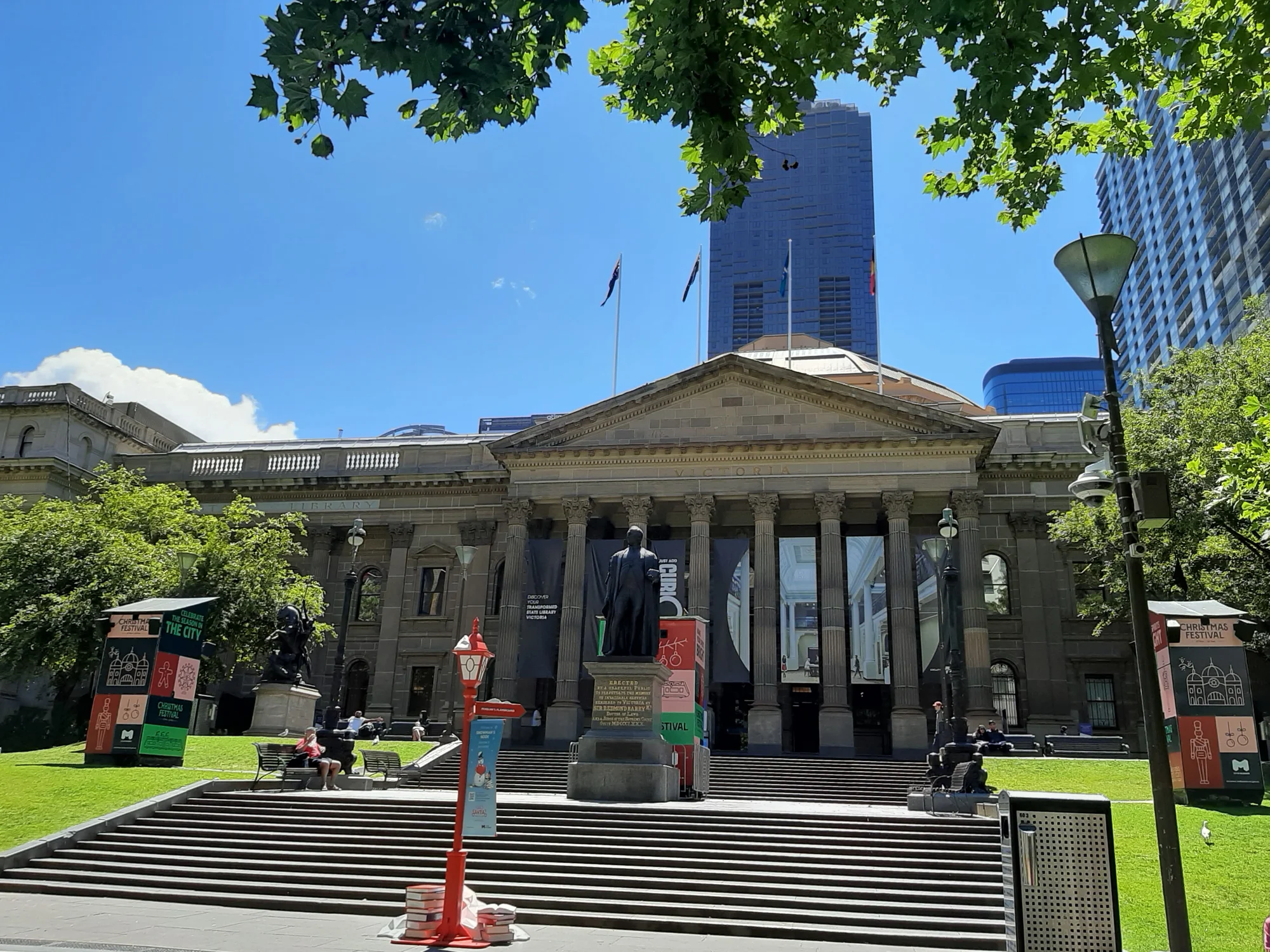 Main entrance of the State Library Victoria in Melbourne, featuring impressive architectural details and an urban backdrop.