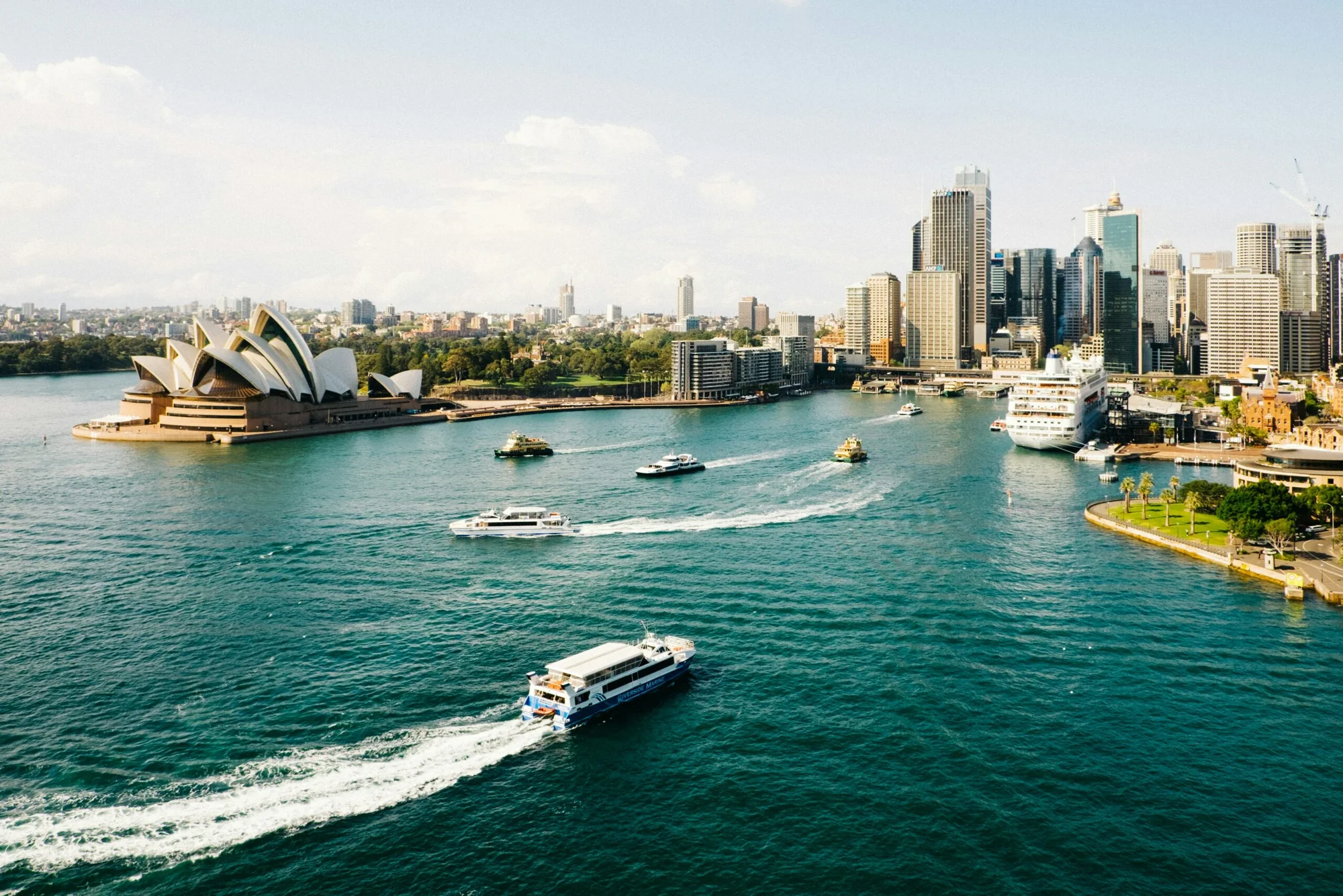 The Sydney Opera House with cloudy skies and the wharf in the foreground, a well-known tourist attraction in Australia.