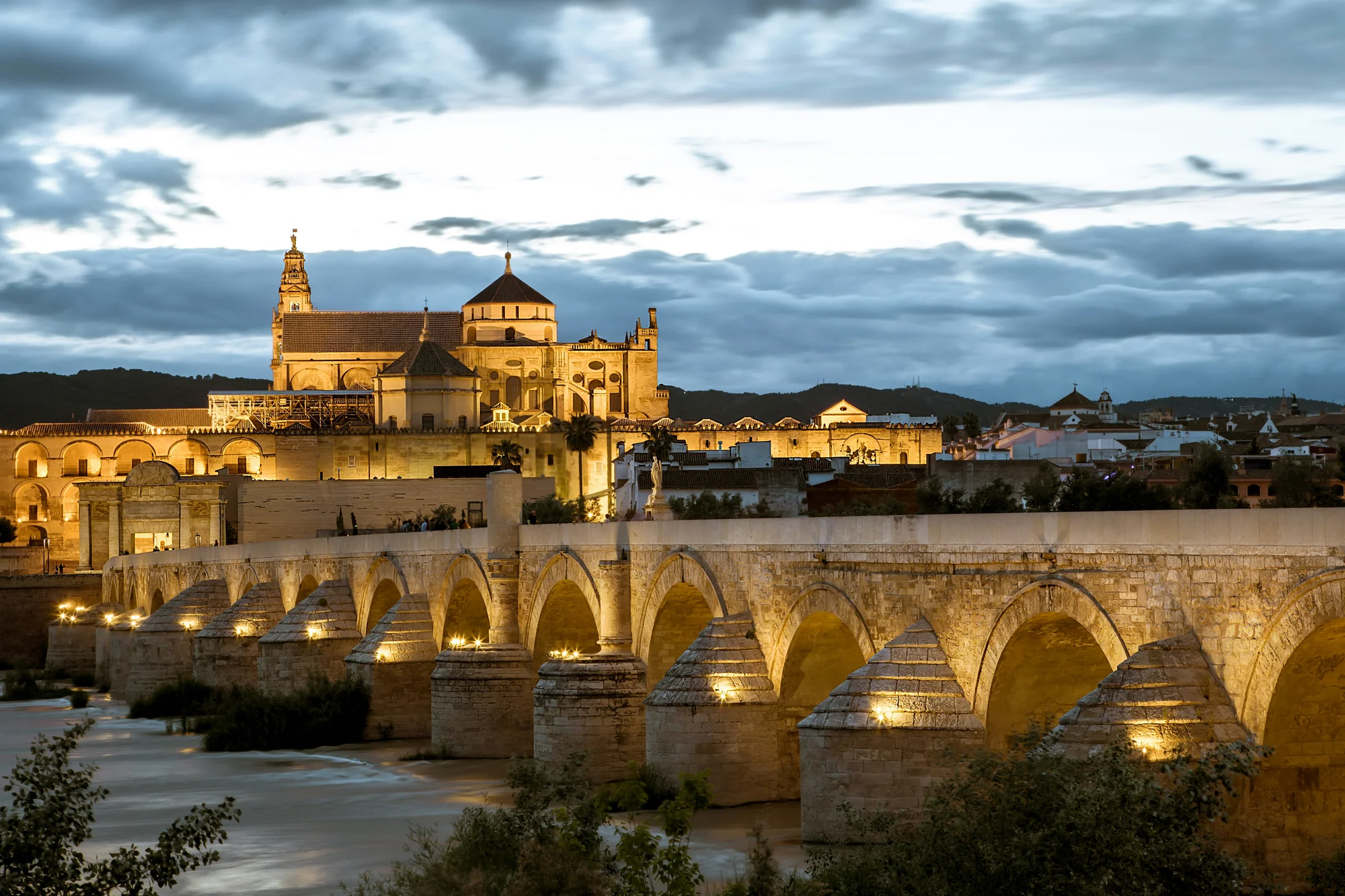Roman Bridge lit up alongside the Mezquita in Cordoba, Argentina, in the evening.
