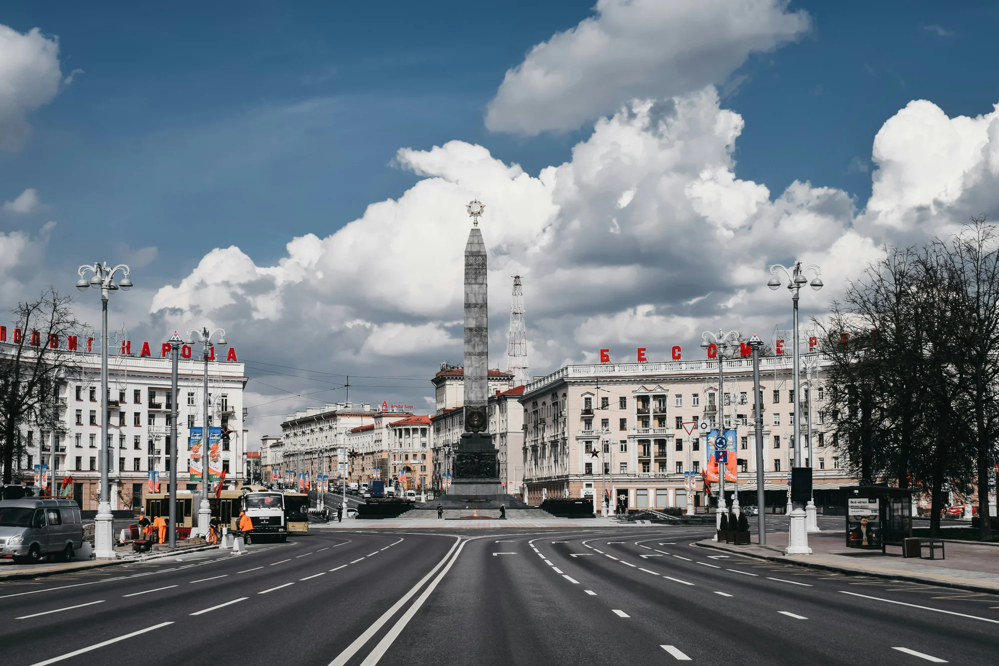 Victory Monument in Minsk, Belarus, against a blue sky and historic buildings.