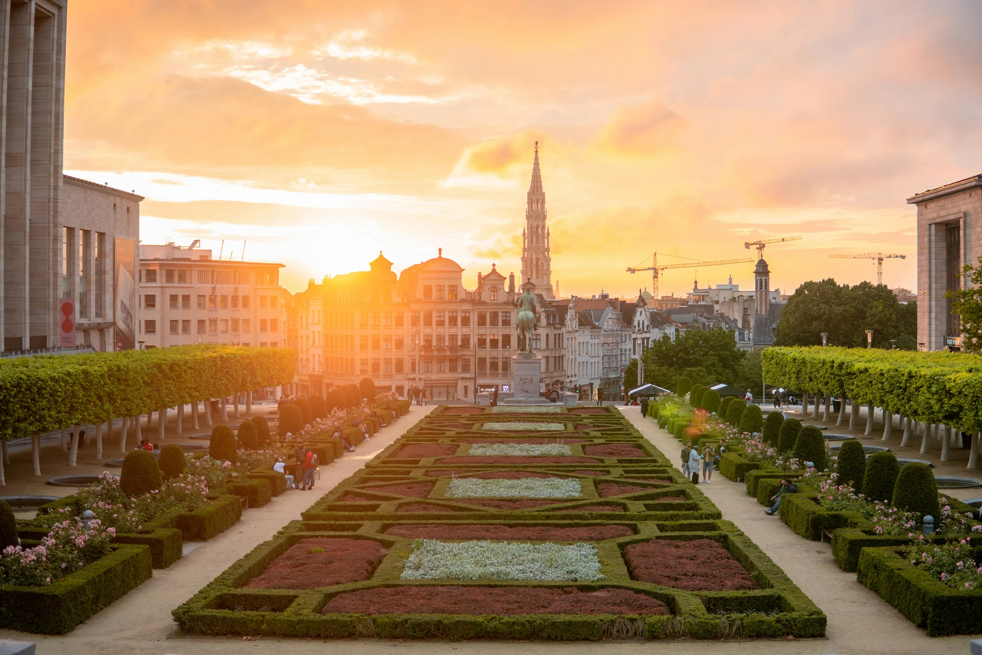 Mont des Arts Garden in Brussels at sunset, with the city town hall visible in the background.