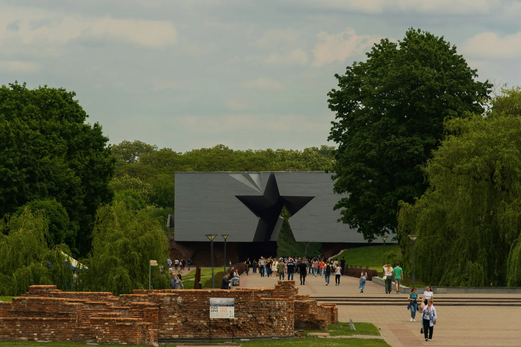 View of Brest Fortress in Belarus with its star-shaped main entrance and tourists exploring the area.