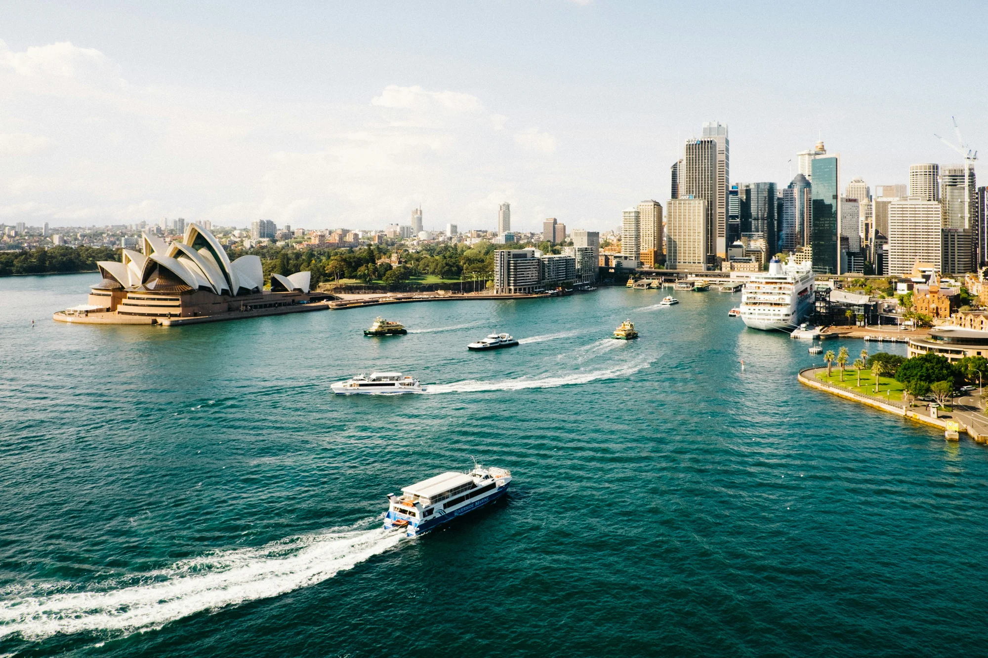 View of Sydney Harbour featuring the Opera House and modern skyline in the background.