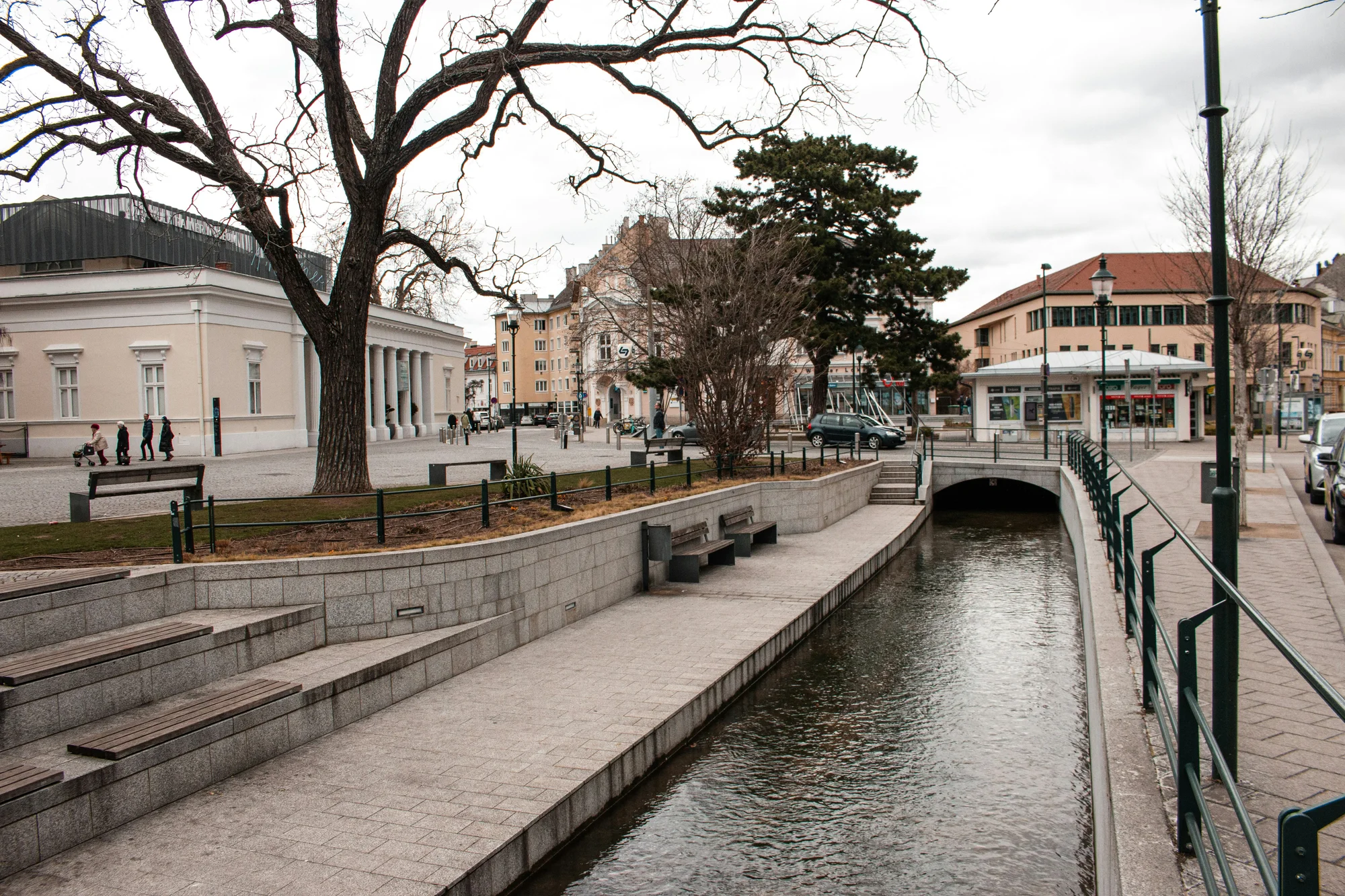 Canal in Baden bei Wien surrounded by historic buildings and pedestrian zones.