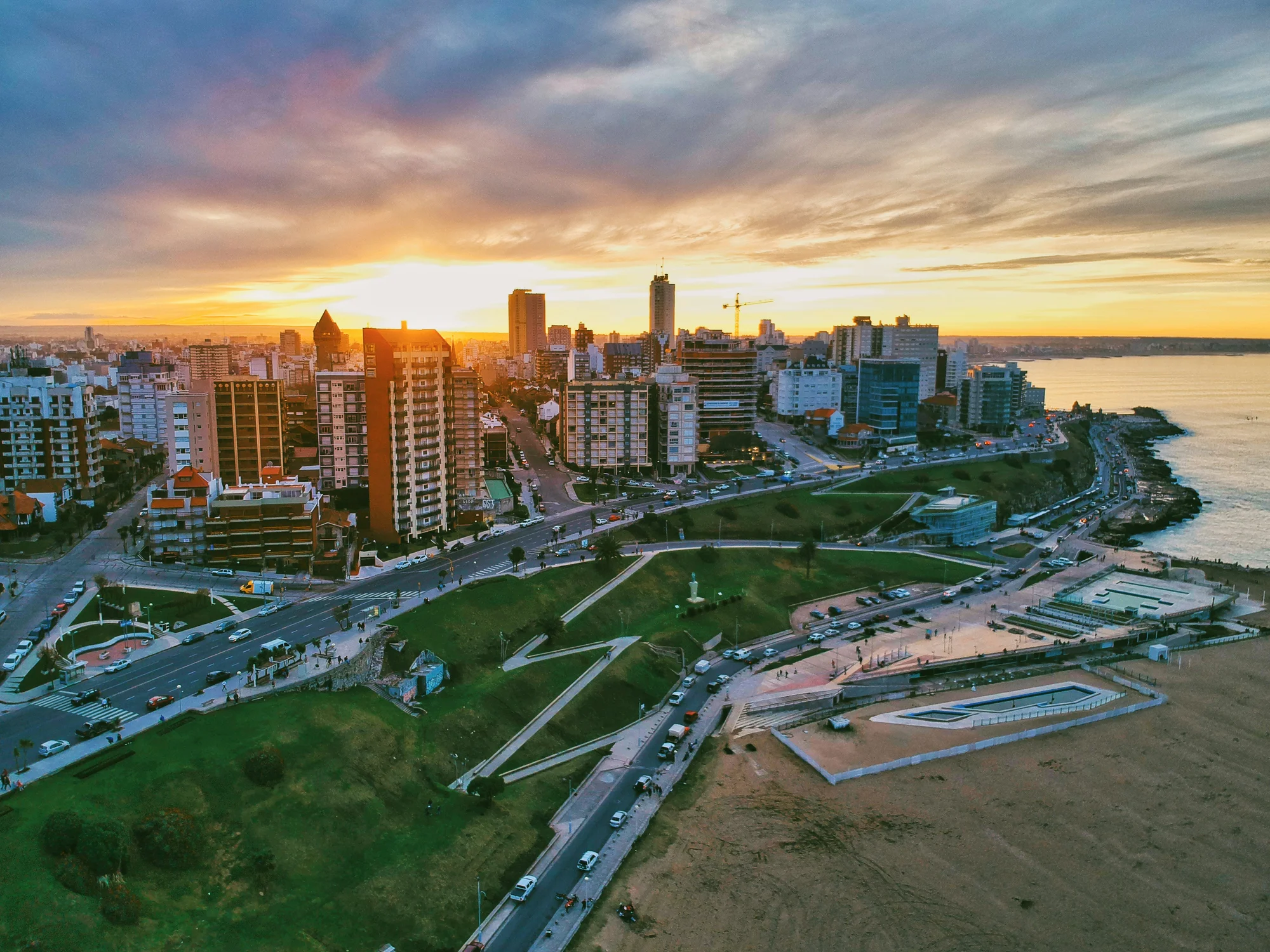 Aerial image of Mar del Plata, Argentina, during sunset, featuring the city and the sea.