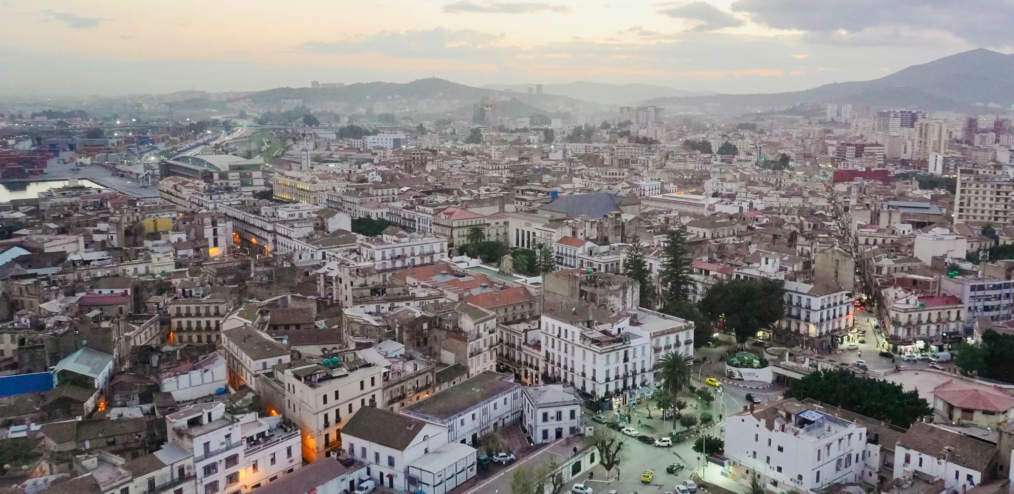 Aerial view of Annaba, Algeria, featuring colonial-style buildings and natural scenery in the background.