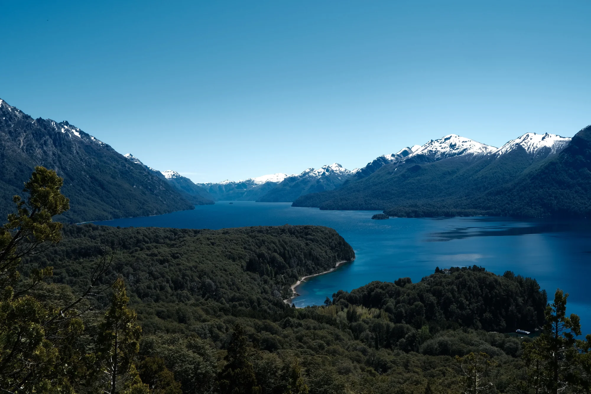 Panoramic view of Nahuel Huapi Lake with snow-capped mountains in Bariloche.
