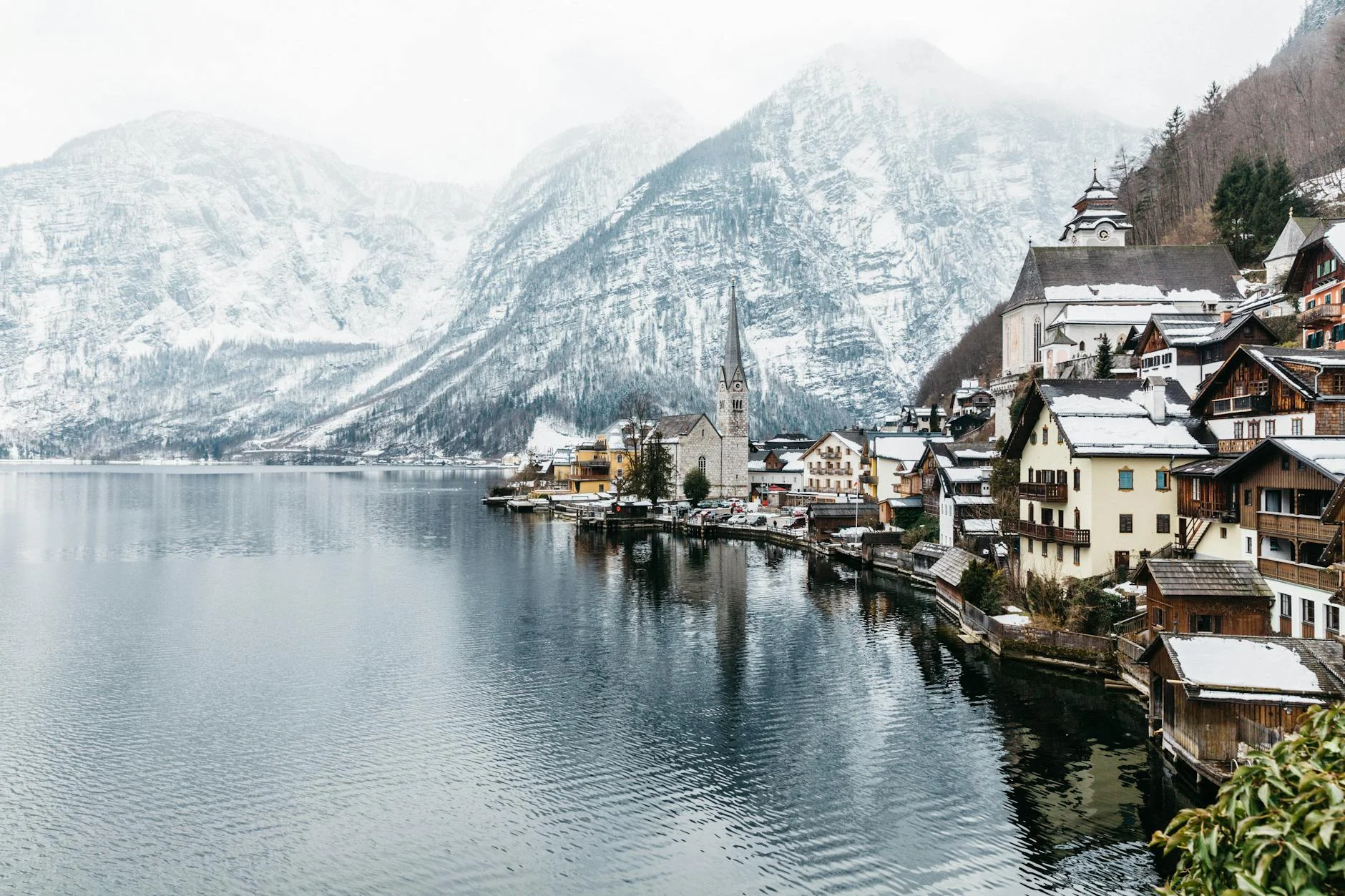 Panoramic view of Hallstatt, Austria, snowy mountains and clear lake.